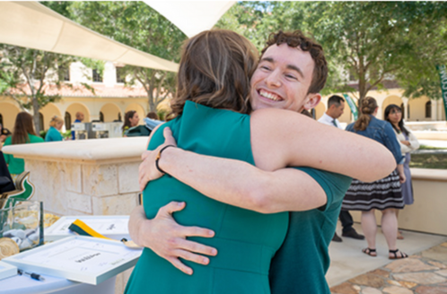 USF honors student hugs Assistant Dean Cayla Lanier at graduation ceremony