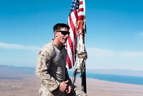 Ryan Powers stands near an American flag