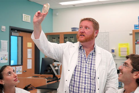 Shaw examining MRSA under the light in a dish