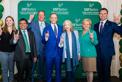 Group poses in front of Bellini College of Artificial Intelligence, Cybersecurity and Computing backdrop