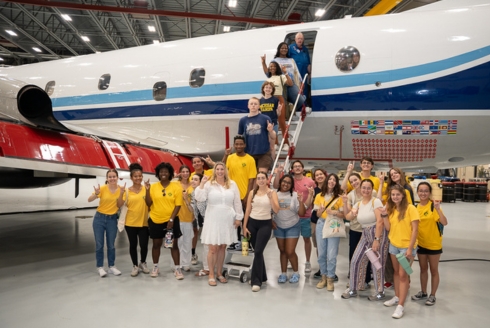 Dr. Jennifer Collins, professor in the School of Geosciences and principal investigator on Weather, Climate, and Society REU, with two REU groups at USF this summer, one from the Tampa campus, and one from the St. Petersburg campus, on a P-3 Orion plane which is used to fly into hurricanes.  (Photo by Corey Lepak)