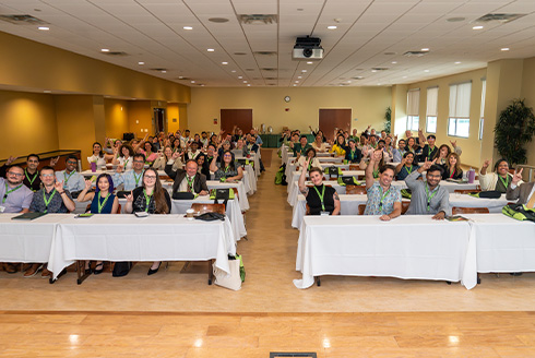 new faculty sit at long tables during faculty orientation session