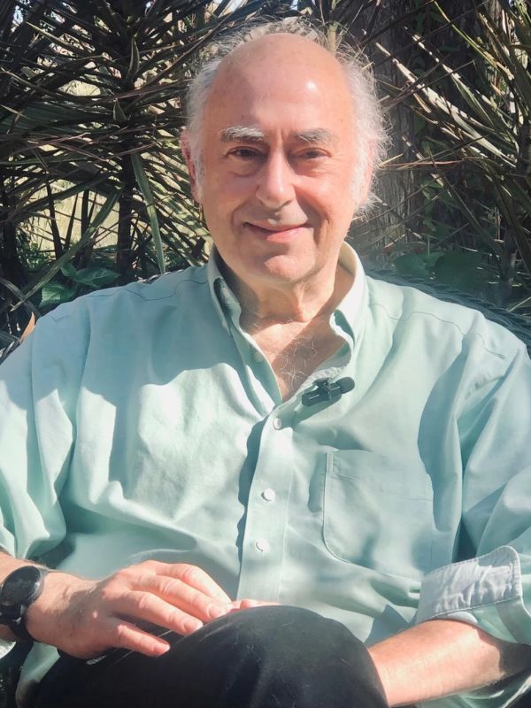 Author Mark Leib sitting in front of trees in chair.