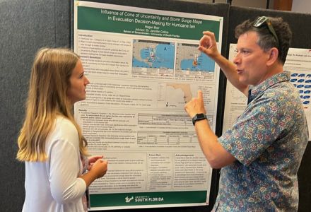 Blair (left) presenting her poster to Dr. Gabriel Vecchi, hurricane researcher from Princeton University, during the symposium. (Photo courtesy of Jennifer Collins)