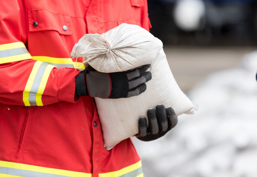 Emergency response person holding sandbag
