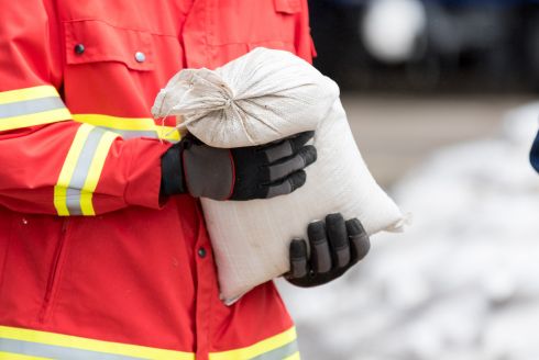 Emergency response person holding sandbag