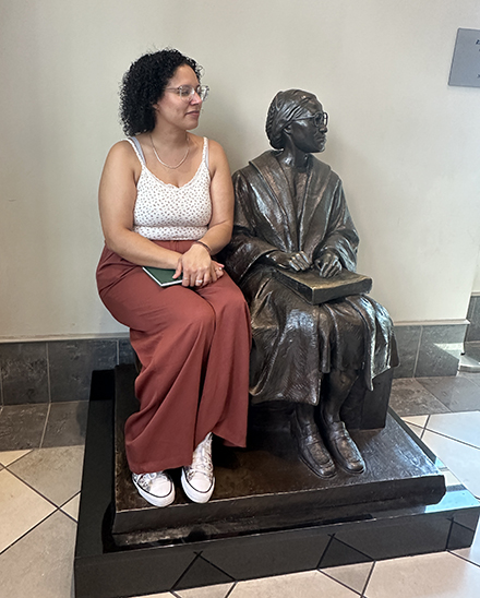 Evita Garcia poses beside a bronze statue of Rosa Parks.