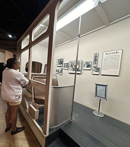 Nuavia Stewart examines a "Back of the Bus" exhibit.