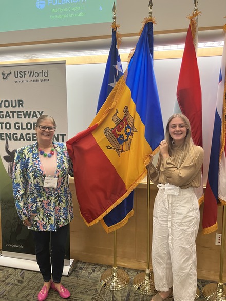 Dr. Judithanne McLauchlan (left) with Taylor Herman (right) posing with the flag of Moldova. (Photo courtesy of Taylor Herman)