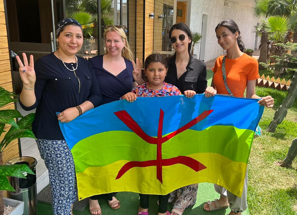 Heide Castañeda (second from left) poses with the Amazigh flag on a recent trip to Morocco