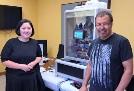 Co-investigators (from right) Chris Ross (Engineering Resources Group) and Yunhee Ji (post-doctoral student at USF) with the Automated High Through-Put Comet Assay Device (AHTP-CAD). (Photo courtesy of Dr. Marcus Cooke)