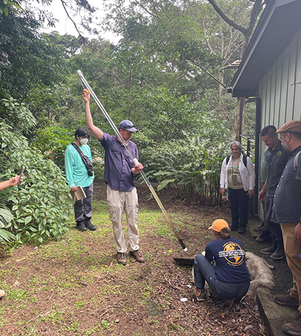 Dr. Kevin Orner demonstrates how to collect a sample from a septic tank chamber. (Photo courtesy of Dr. Nancy Romero-Daza)