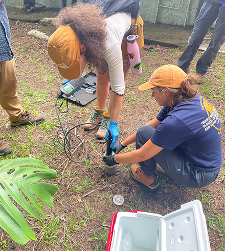 Students Tailyn Osorio (left) and Sarah Yingling (right) measuring gas emissions from sludge samples. (Photo courtesy of Dr. Nancy Romero-Daza)