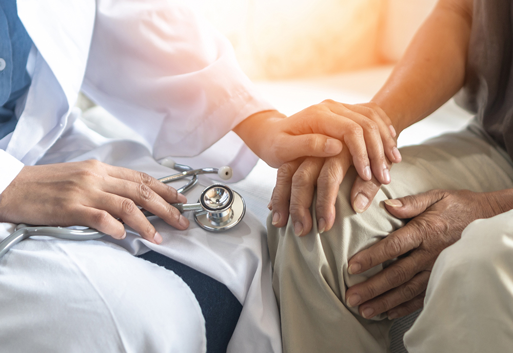 physician's hand comforting patient