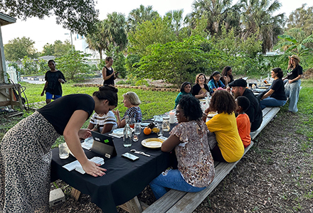 Community dinner catered by WellFed Community and the USF Food Sovereignty Initiative. Cornerstone Ministries community garden in background. (Photo courtesy of Will Schanbacher, PhD)