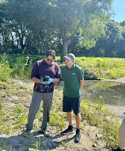 Christian Wells examining the levels at Aaron’s Pond. (Photo courtesy of Christian Wells, PhD)