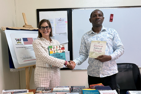 Dr. McLauchlan presents her book donation to the Center for the Study of the United States with Center director Dr. Edward Kaweesi. (Photo courtesy of Judithanne Scourfield McLauchlan)