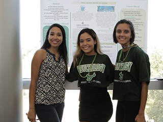 three students standing in front of sign