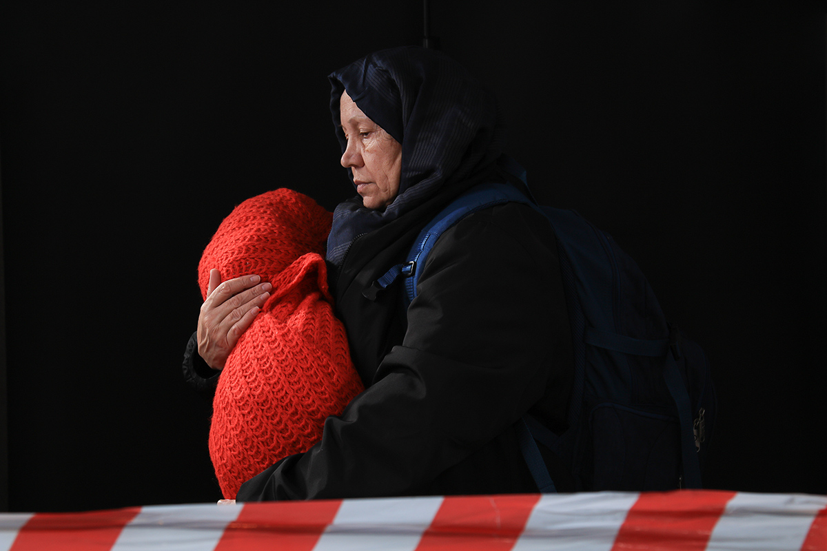 senior woman in hijab carrying infant