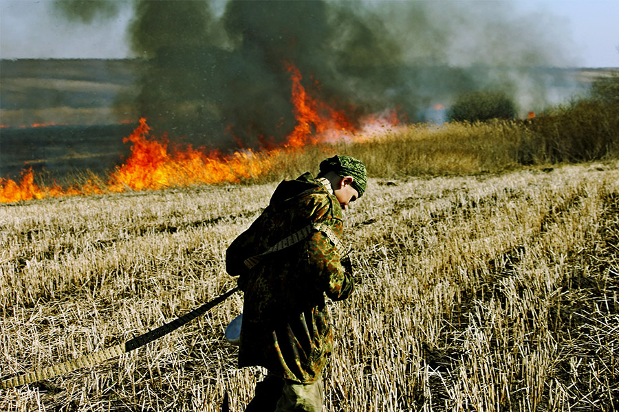 soldier walking through burning field