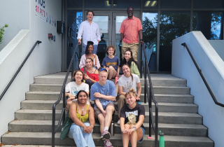 students sitting on stairs in front of building