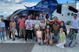 group of students standing in front of a noaa plane