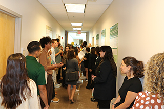 Poster presenters and attendees in the hallway