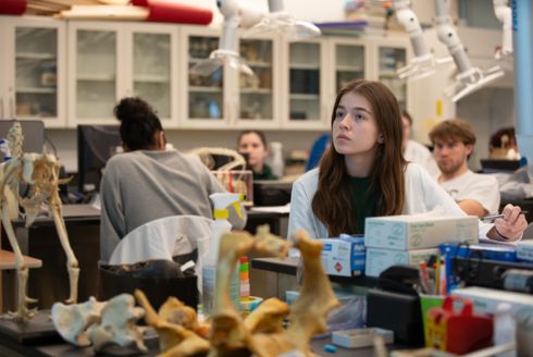 student sitting at lab table in classroom