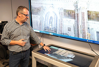 faculty member pointing to slide image on a projector