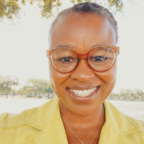 Headshot of Dr. Antoinette Jackson, LHI Director. She is wearing her hair styled tightly into a bun, carmel colored glasses and wearing a lime green blazer.