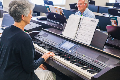 Participants in a research class play piano.