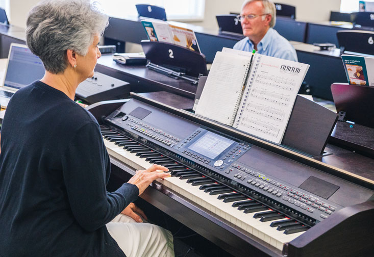 Participants in a research class play piano.