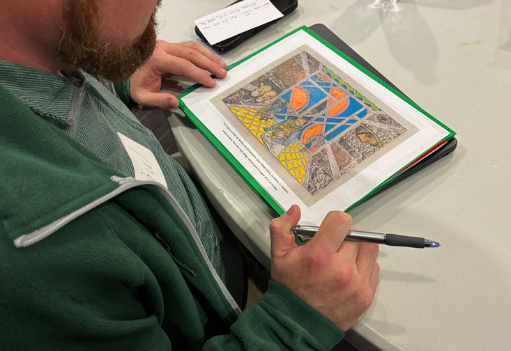 A student looks at a print of an artwork.