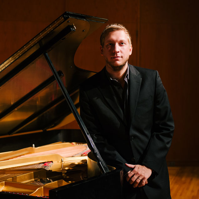 Stijn De Cock leaning against a piano