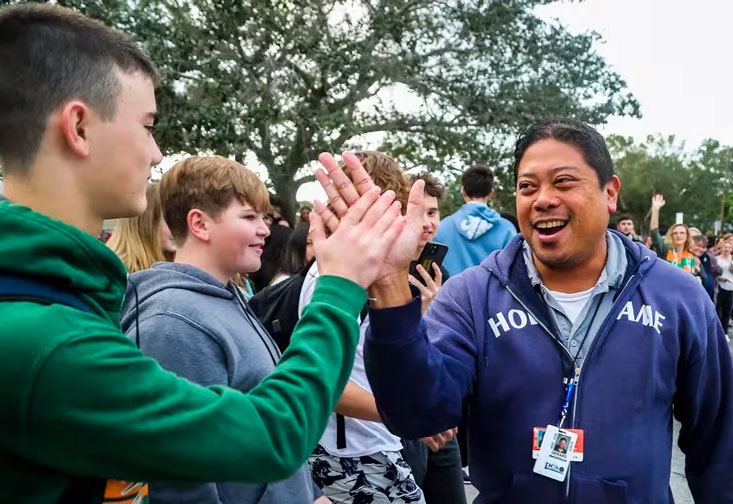 Gerard Madrinan, Pinellas County's Teacher of the Year, gives high-fives to students as he arrives at Seminole High after the traditional limousine ride to school Tuesday. Following behind, at right, is principal Jane Lucas. Madrinan was awarded the honor in a ceremony Monday night at Mahaffey Theater in St. Petersburg. [ DIRK SHADD | Times ]