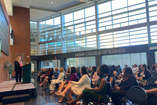 Woman speaking to crowd in atrium