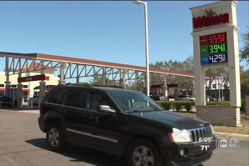 Image of car leaving a Wawa gas station. Signage displays the gas prices at the time. 