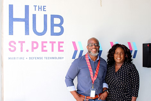 black couple in front of a sign