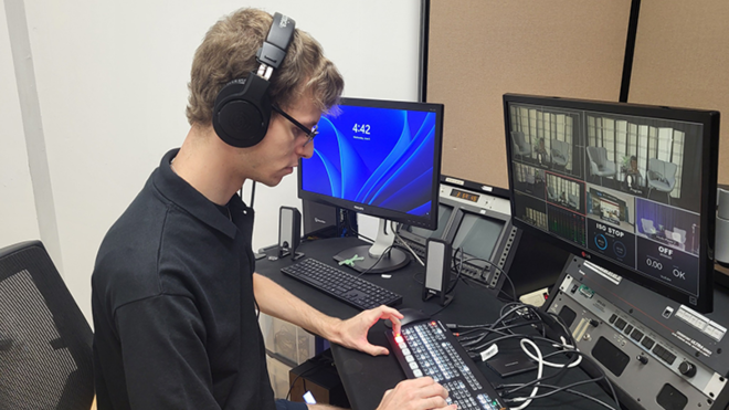 Student wearing headphones uses computer