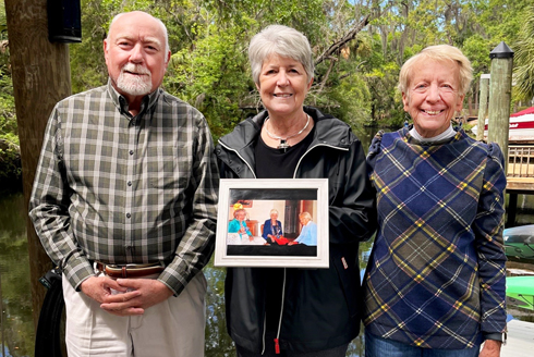 Roger Boothroyd, Catherine Batsche, and Mary Armstrong hold a photograph of their mothers