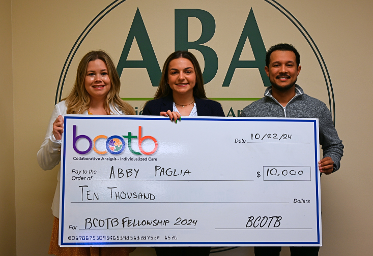 Abby Paglia receives a check alongside Anthony Concepción and Heatherann Tenowich