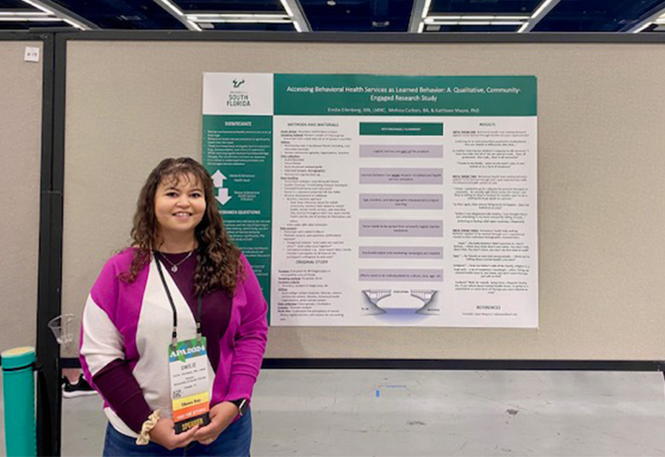 Emilie Ellenberg stands in front of her research poster