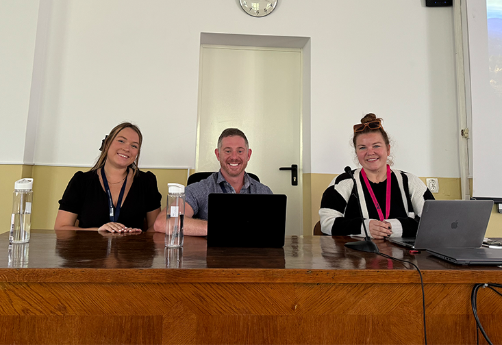 Kaylee Eckelman, C. Jordan Howell, PhD, and Katelyn Smith sit at a table