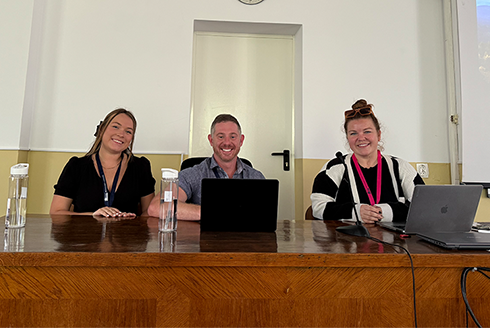 Kaylee Eckelman, C. Jordan Howell, PhD, and Katelyn Smith sit at a table