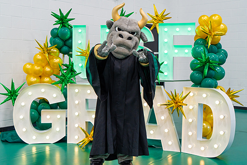 Rocky in front of a USF Grad sign