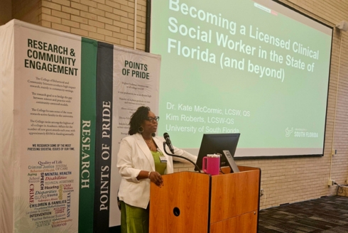 Kim Roberts standing at a podium