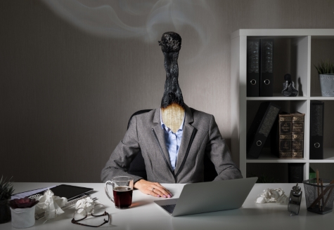 Professional in an office with a burnt matchstick for a head