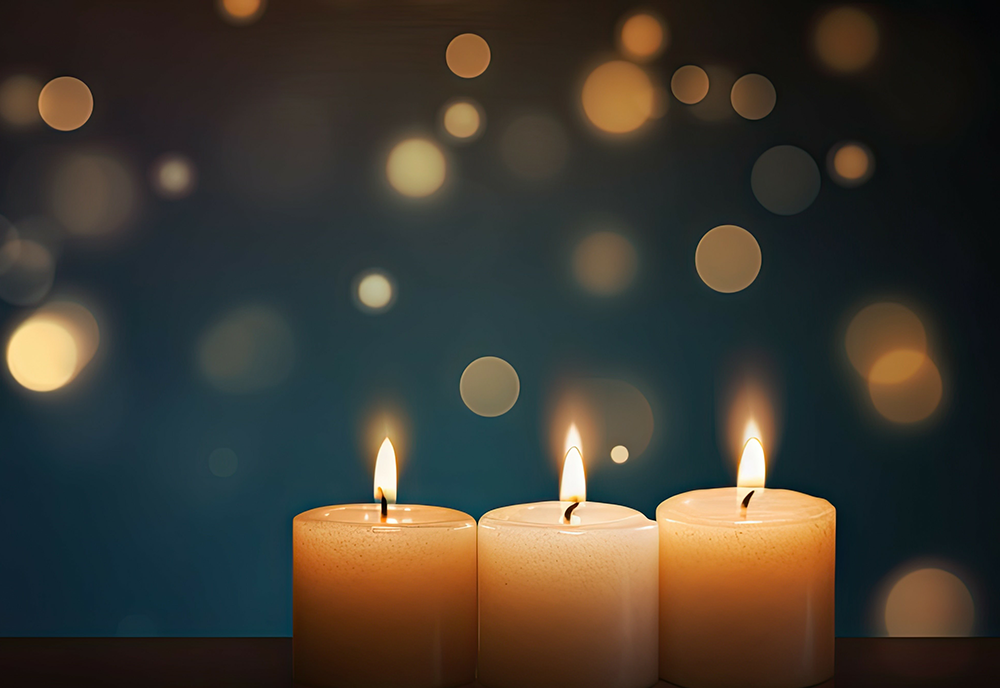 three candles are lit with a blue background