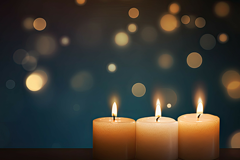 three candles are lit with a blue background