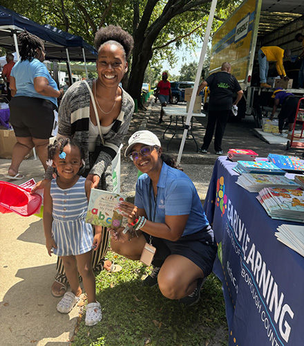 sonia poses with young girl and book at event